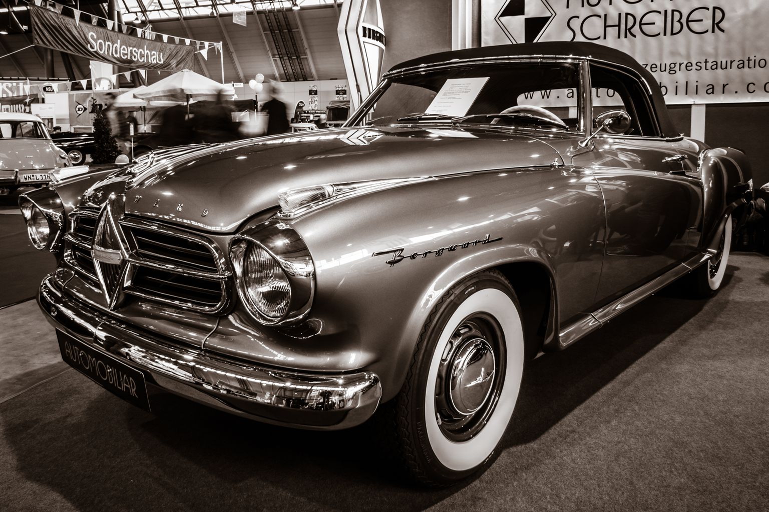 Sepia getöntes Bild eines Oldtimers der Marke Borgward mit Weißwandreifen, der in einem Ausstellungsraum ausgestellt ist.